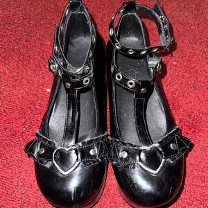Black platform Mary Jane shoes with heart buckles